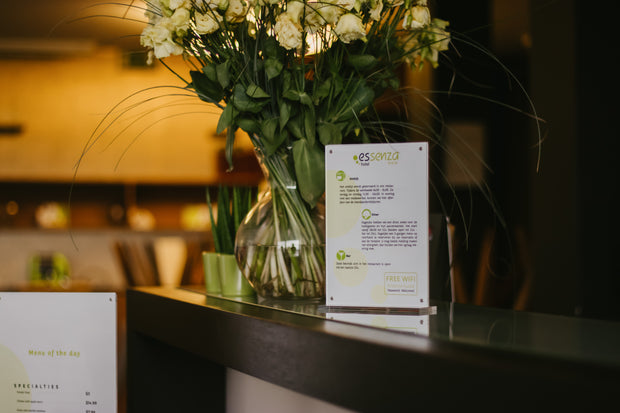 Vase of flowers with an acrylic menu on a counter in a restaurant setting