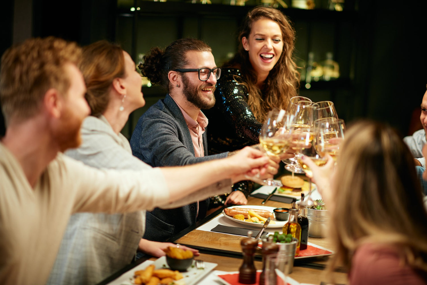 Group of people enjoying a meal and drinks together in a restaurant.