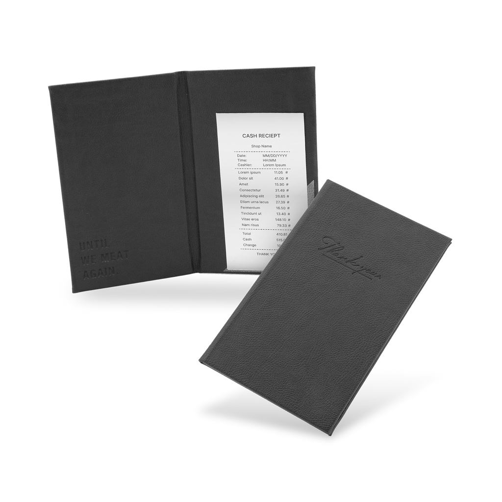 A black bill binder with a menu partially visible, closed and open, with a visible logo on the front cover.