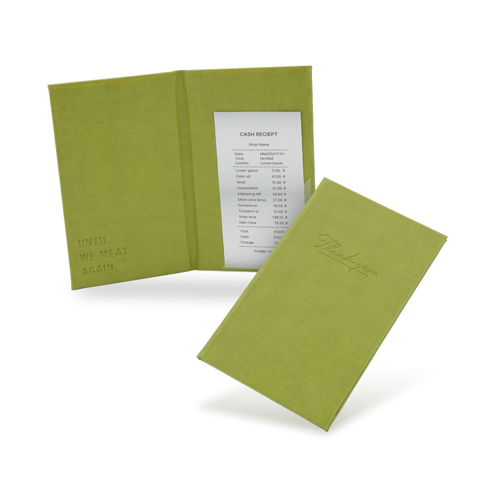A green bill binder with a menu partially visible, closed and open, with a visible logo on the front cover.