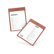 Two clipboards with brown edges and white menu sheets, one with 'COCKTAILS' and the other with 'MENU' written at the top, both lying at an angle.
