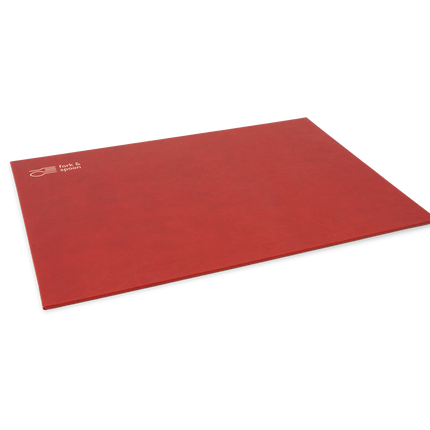 A red rectangular placemat made from vegan leather, with a subtle textured surface and visible stitching along the edges.