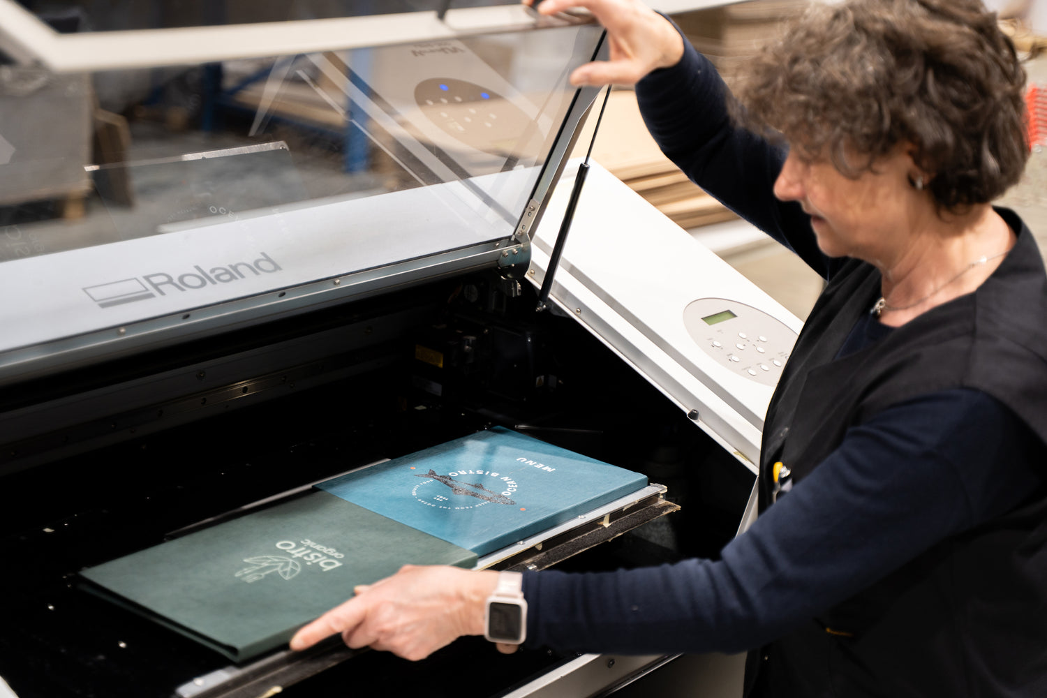 A lady making personalised menus in a factory setting