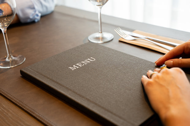 Grijze Linnen Menukaart met Logo op Tafel in een Brasserie